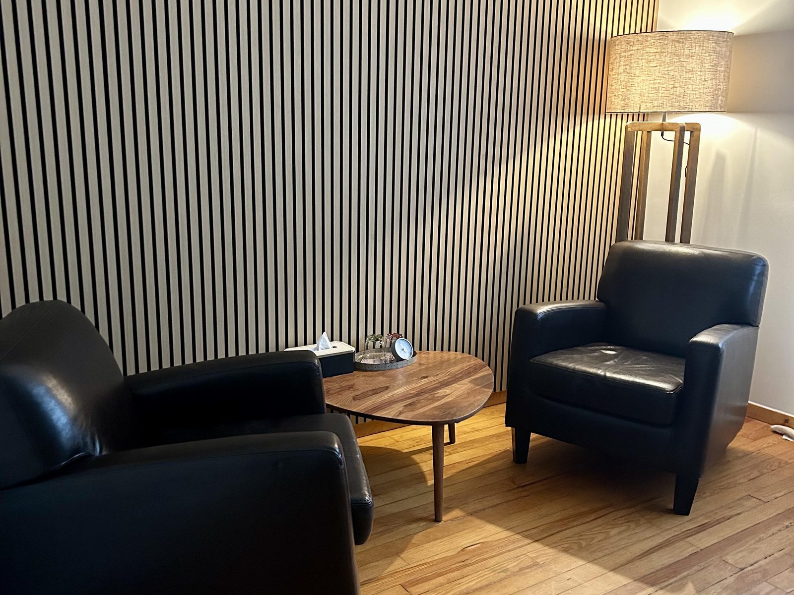 L’espace d’entretien : deux fauteuils en cuir de part et d’autre d’une table basse